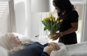 caregiver bringing client flowers in bed